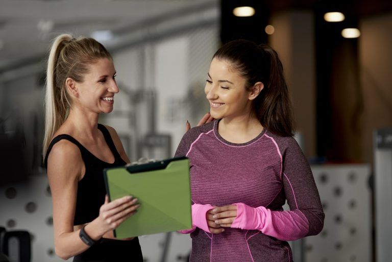 cheerful instructor and woman at gym 6CD8YDX 3 768x513