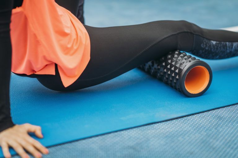 female athlete using foam roller YEM6ZHF 1 768x512
