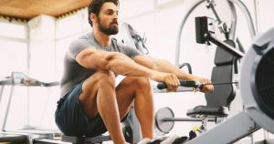 fit man training on row machine in gym X59Q8RD 300x158