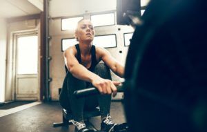 fit young woman exercising on a gym rowing GLT3UW6 300x191