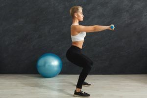 fitness woman doing squat on grey background P529VYL 1 1 300x200