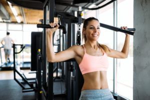 happy woman exercising on a shoulder press in 9ZXTCUS 3 300x200