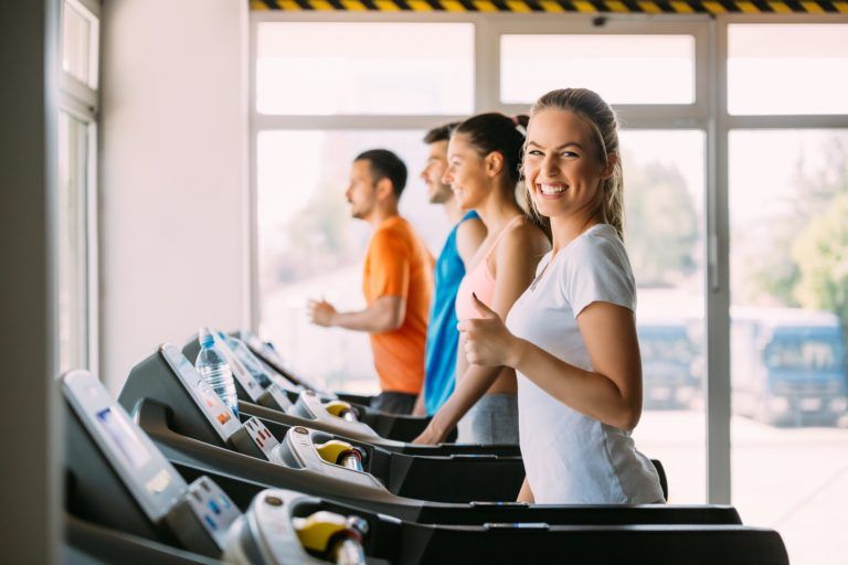 healthy man and woman running on a treadmill in a 9H7FZG4 2 768x512