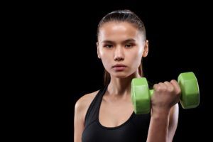 pretty active girl holding green dumbbell in hand 8LUP3QC 1 300x200