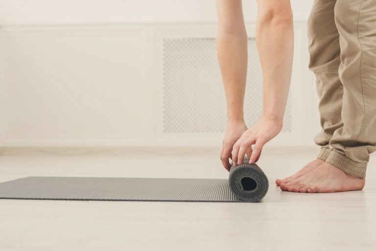 rolling up fitness mat for exercise copy space PZBMGPP 768x512