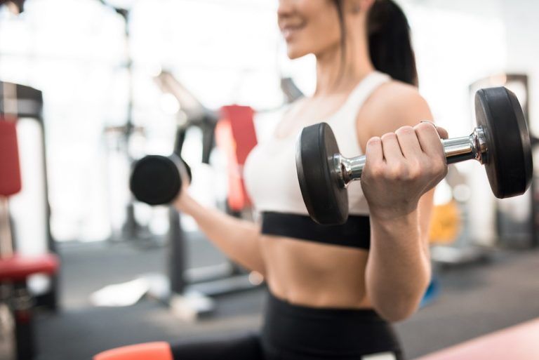 woman training with weights in gym 3XW4MAR 768x513