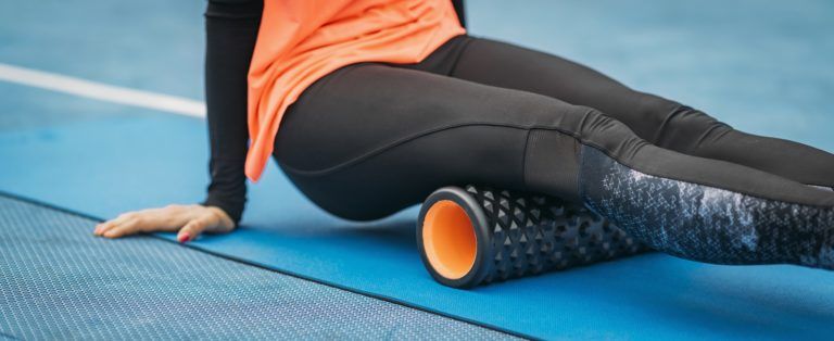 female athlete using foam roller GJH2XRN 768x314